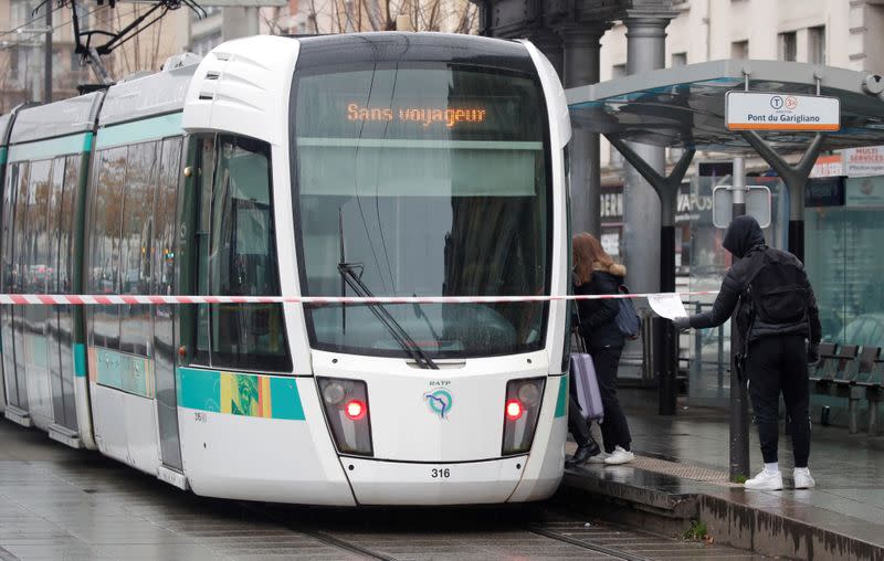 Passengers wait for a tramway during a nationwide strike by French SNCF railway workers in Paris