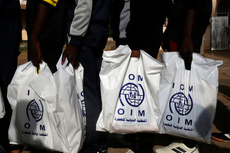 Gambian migrants deported from Libya stand in line with plastic bag from the International Organization for Migration (IOM) as they wait for registration at the airport in Banjul, Gambia April 4, 2017. REUTERS/Luc Gnago