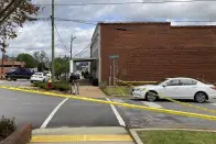 Investigators work at the site of a fatal shooting in downtown Dadeville, Ala., on Sunday, April 16, 2023. Several were killed during a shooting at a birthday party Saturday night, the Alabama Law Enforcement Agency said. (AP Photo/Jeff Amy)