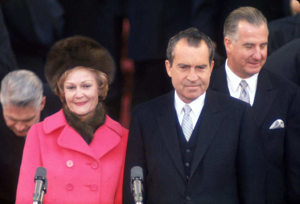 Pat Nixon stands with husband Richard Nixon during his 1969 inauguration. To the right of the couple is Nixon's vice president, Spiro Agnew. After their ticket won a second term in 1972, both men resigned their offices in disgrace.