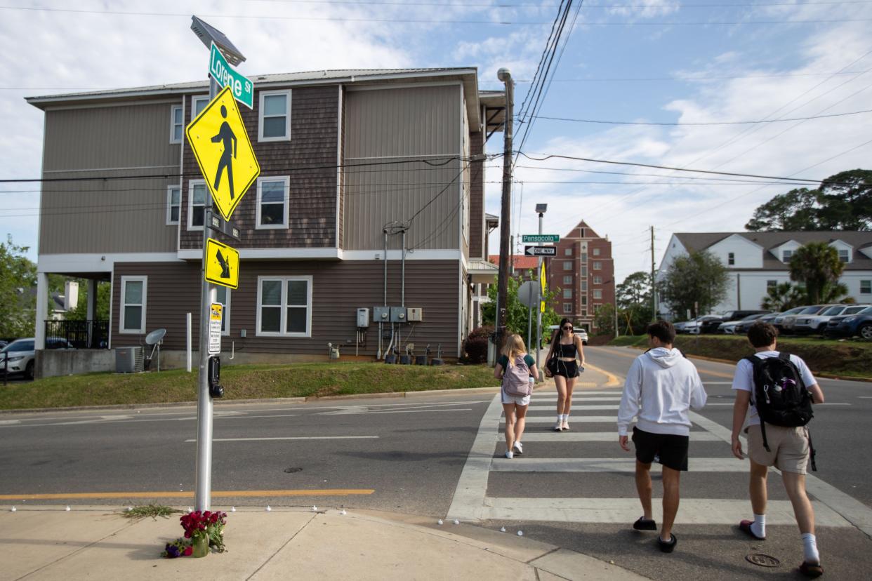 Flowers and tea light candles are placed at the base of a crosswalk sign at the intersection of Pensacola Street and Lorene Street after a Florida State University student was struck and killed by a vehicle on Monday night, April 29, 2024.