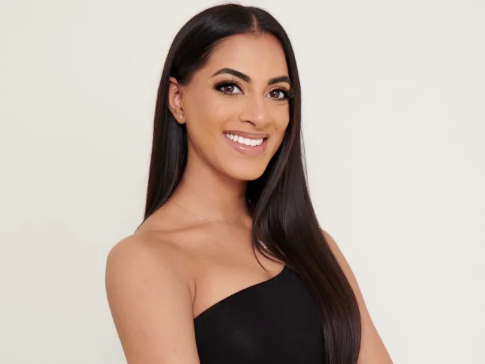 A headshot of Tanvi Shah smiling with her arms crossed.