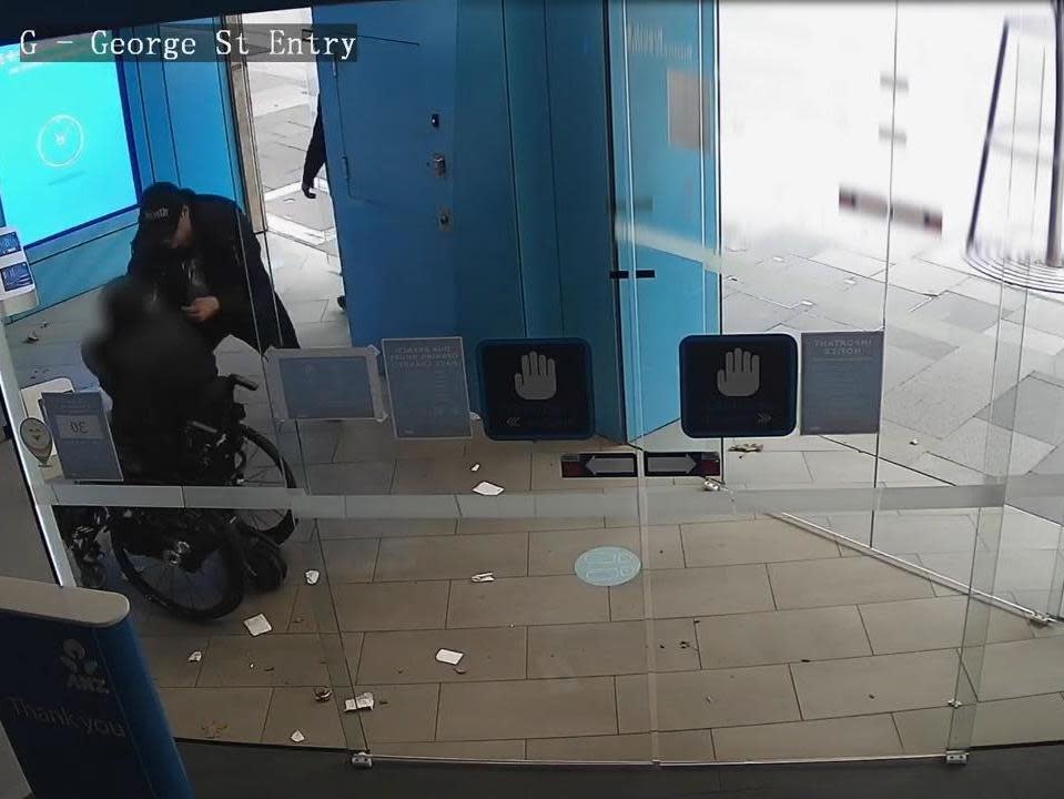 Two men allegedly snatched money out of the hands of a wheelchair user in Sydney: New South Wales Police