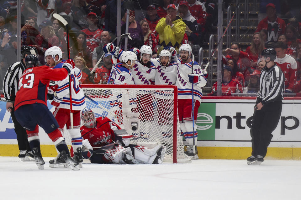 New York Rangers players celebrate after scoring against the Washington Capitals during the first period in Game 4 of an NHL hockey Stanley Cup first-round playoff series, Sunday April 28, 2024, in Washington. (AP Photo/Tom Brenner)