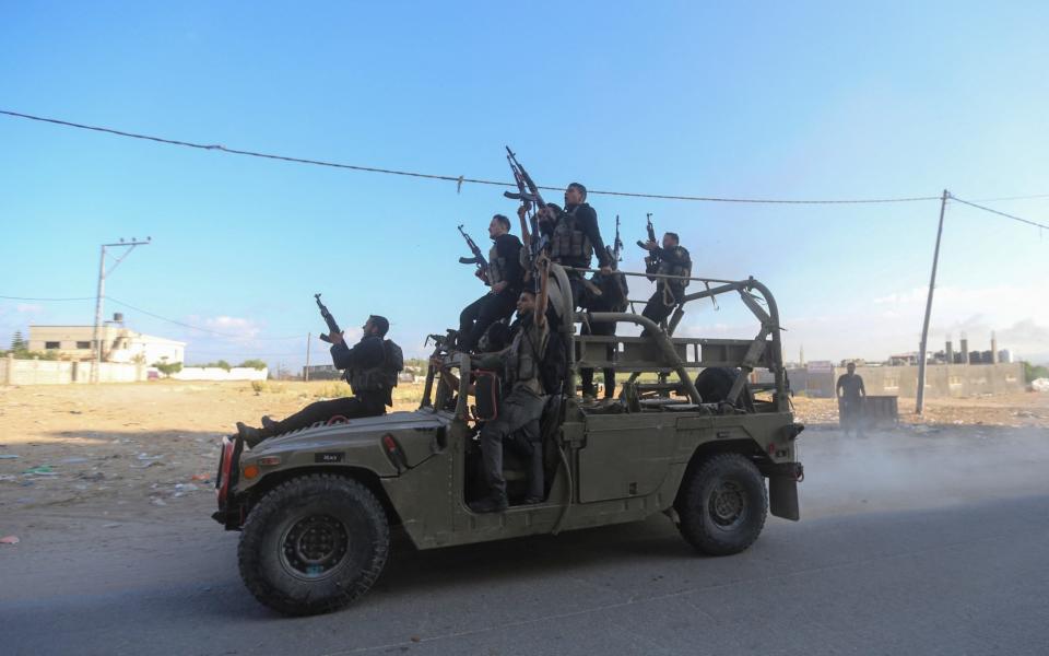 Palestinian militants ride an Israeli military vehicle seized by gunmen who infiltrated areas of southern Israel