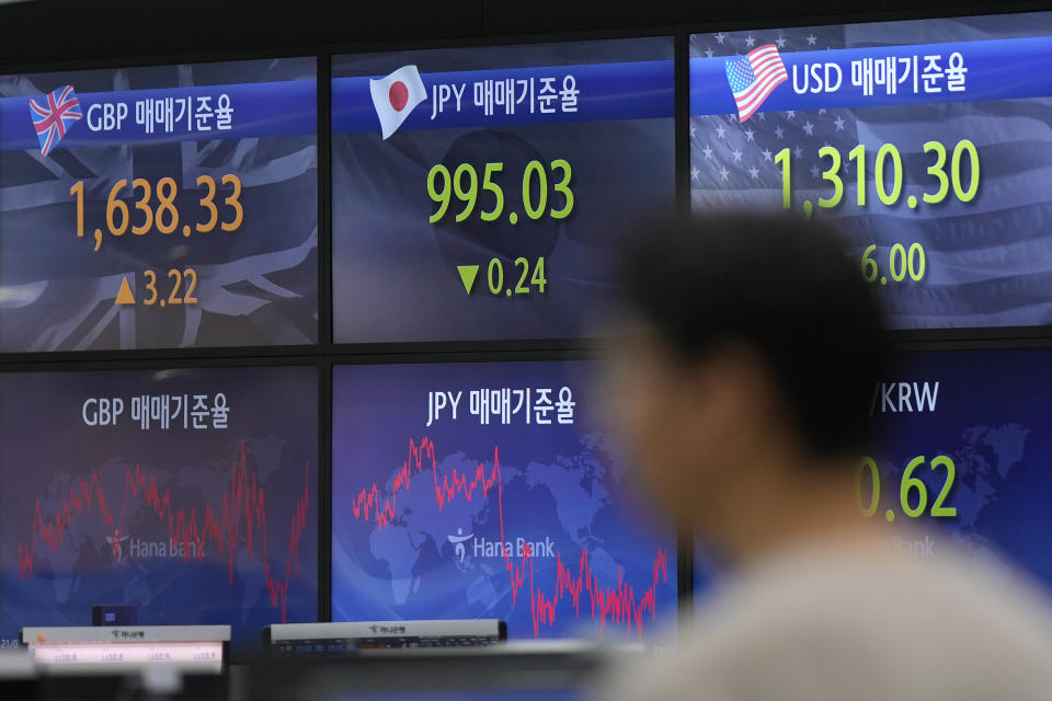 A currency trader walks by the screens showing the foreign exchange rates at a foreign exchange dealing room in Seoul, South Korea, Wednesday, April 5, 2023. Asian shares were trading mixed Wednesday following a decline on Wall Street after reports on the U.S. economy came in weaker than expected. (AP Photo/Lee Jin-man)