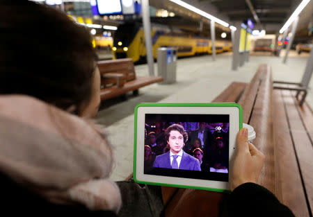 A woman looks at Jesse Klaver of the Green Party (Groen Links) on her iPad during the political debate ahead of the Dutch elections, at the Central Train Station in Utrecht, Netherlands, March 14, 2017. REUTERS/Michael Kooren