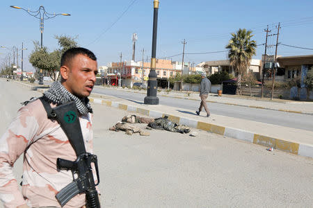 ATTENTION EDITORS - VISUALS COVERAGE OF SCENES OF DEATH An Iraqi soldier carries his weapon near corpses of Islamic State militants killed in clashes in Mosul, Iraq, February 6, 2017. REUTERS/Ahmed Saad