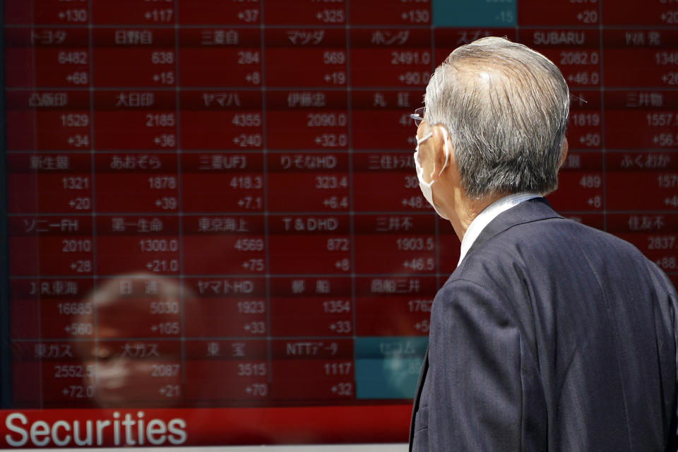 A man wearing a face mask to help curb the spread of the coronavirus looks at an electronic stock board showing Japan's Nikkei 225 index at a securities firm in Tokyo Friday, May 8, 2020. Asian shares surged Friday on optimism the worst of the economic fallout from the pandemic may be over, as Wall Street logged its biggest rally in a week. (AP Photo/Eugene Hoshiko)