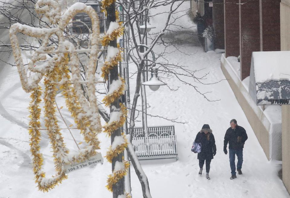 Pedestrians make their way along College Avenue during a snowstorm Friday, January 12, 2024, in Appleton, Wisconsin.