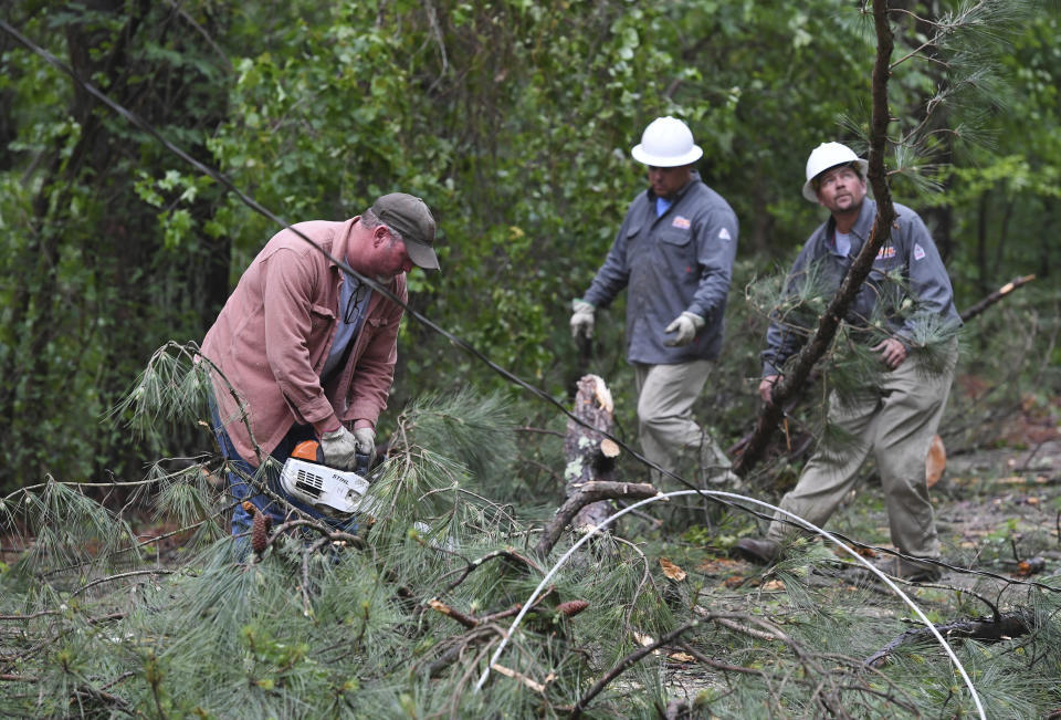 A Tupelo Water and Light crew works to clear downed trees and power lines along Oakview Drive in Tupelo, Miss., Monday, May 3, 2021. A line of severe storms rolled through the state Sunday afternoon and into the nighttime hours. Late Sunday, a “tornado emergency” was declared for Tupelo and surrounding areas. (AP Photo/Thomas Graning)