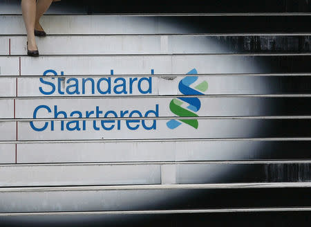 A woman walks down the stairs of the Standard Chartered headquarters in Hong Kong in this October 13, 2010 file photo. REUTERS/Bobby Yip/File Photo