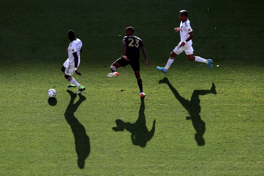 The Galaxy's Sega Coulibaly, left, and Julian Araujo, right, control the ball against LAFC's Kellyn Acosta on April 9, 2022.