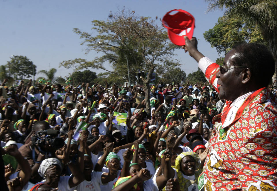 FILE - In this Thursday, June 26, 2008 file photo, Zimbabwe's President Robert Mugabe, right, greets the crowd at his final rally in Chitungwiza, Zimbabwe. Mugabe, the longtime leader of Zimbabwe who was forced to resign in 2017 after a military takeover, has died at 95. (AP Photo/Tsvangirayi Mukwazhi, file)