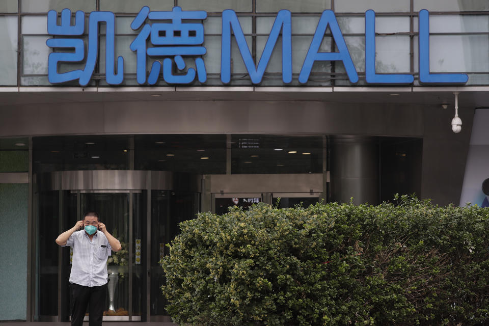 A man puts on a protective face mask to help curb the spread of the new coronavirus as he walks by a shuttered shopping mall following positive cases detected in Beijing, Tuesday, June 23, 2020. China reported close to two dozen new cases of coronavirus on Tuesday a day after a city government spokesperson said containment measures had slowed the momentum of an outbreak in the capital that has infected more than 200 people. (AP Photo/Andy Wong)