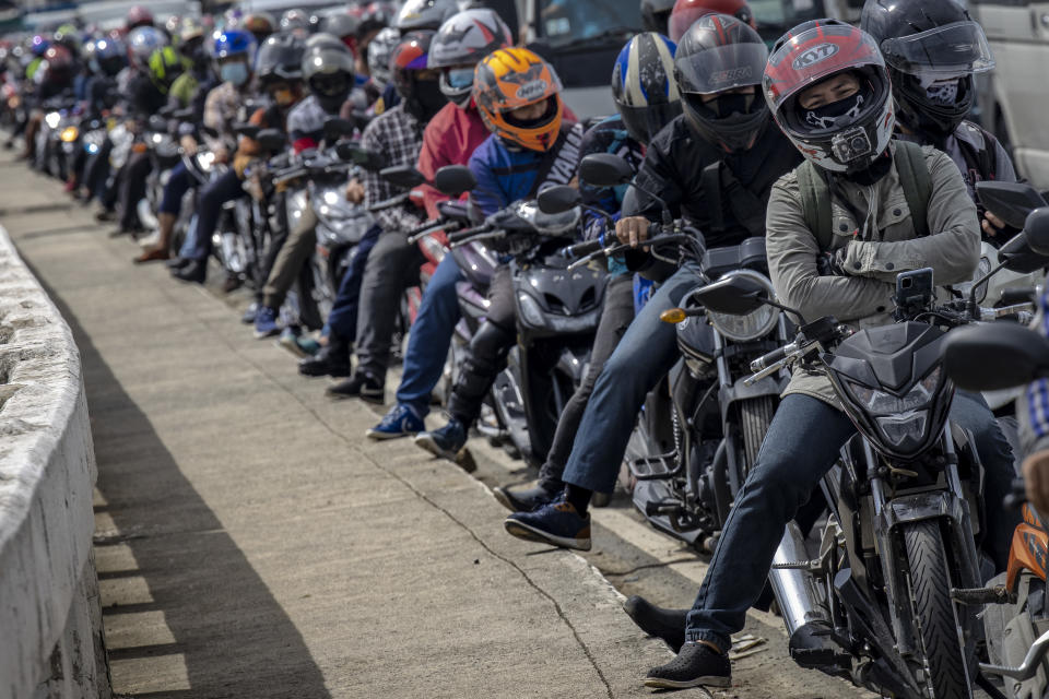 A long line of motorcycle riders form at a quarantine checkpoint on the first day of a reimposed lockdown to curb the spread of COVID-19, on August 4, 2020 in Quezon City, Metro Manila, Philippines. (Photo by Ezra Acayan/Getty Images)