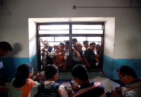 People collect their voters' identity cards at a polling station for the upcoming local election of municipalities and villages representatives in Thimi, Bhaktapur, Nepal, May 11, 2017. REUTERS/Navesh Chitrakar