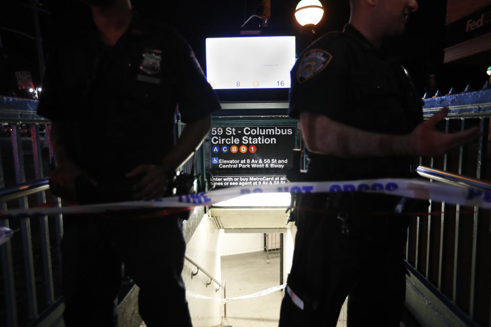 New York City police officers stand guard at a closed subway station during a power outage Saturday, July 13, 2019, in New York. (AP Photo/Michael Owens)