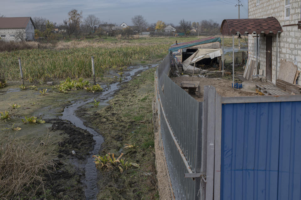 A yard of Olga Lehan's house is seen flooded in the village of Demydiv, about 40 kilometers (24 miles) north of Kyiv, Ukraine, Tuesday, Nov. 2, 2022. Olga Lehan's home near the Irpin River was flooded when Ukraine destroyed a dam to prevent Russian forces from storming the capital of Kyiv just days into the war. Weeks later, the water from her tap turned brown from pollution. (AP Photo/Andrew Kravchenko)