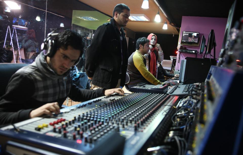 In this Monday, Feb. 3, 2014 photo, Tolo TV staffers work in the Control Room at their office in Kabul, Afghanistan. The proliferation of Afghan media in the past 12 years is one of the most visible bright spots of the fraught project to foster a stable democracy. (AP Photo/Massoud Hossaini)