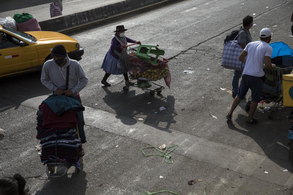 Street vendors who came out to sell their products, ignoring lockdown measures to curb the spread of the new coronavirus, returned to their workspaces after being evicted by police in La Victoria district, in Lima, Peru, Friday, June 19, 2020. (AP Photo/Rodrigo Abd)