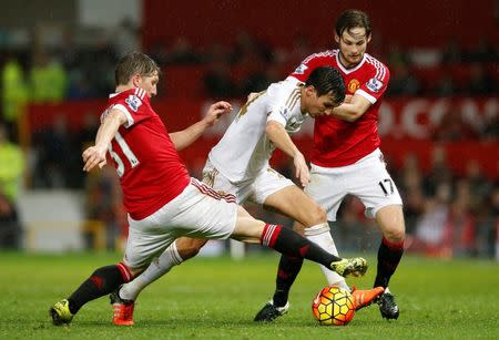 Football Soccer - Manchester United v Swansea City - Barclays Premier League - Old Trafford - 2/1/16 Manchester United's Daley Blind and Bastian Schweinsteiger in action with Swansea's Jack Cork Reuters / Andrew Yates Livepic