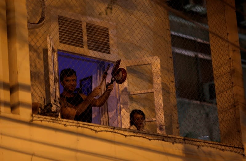 A man bangs a pot at the window of his house as he protests against Brazilian President Jair Bolsonaro during the coronavirus disease (COVID-19) outbreak in Rio de Janeiro