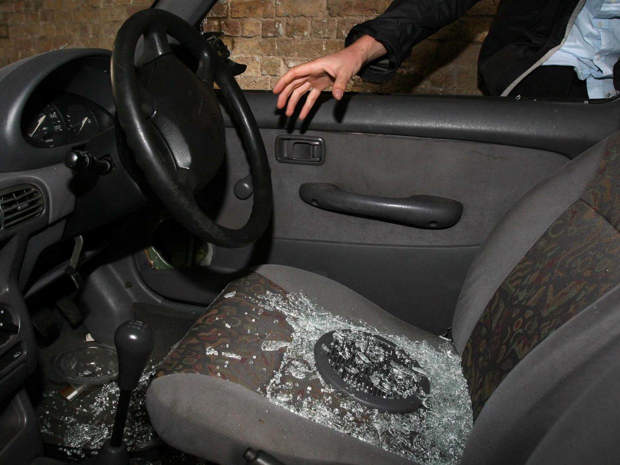 Undated file photo of a hand reaching into a car through a broken window: PA