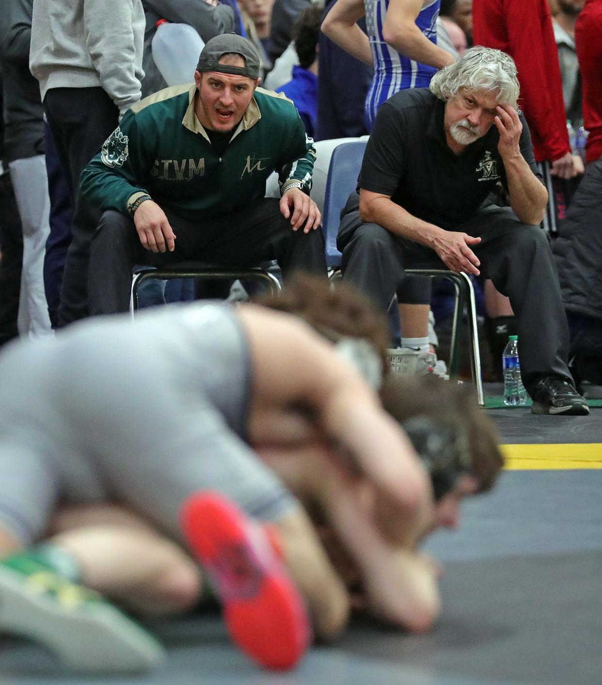 STVM wrestling coach Nic Skonieczny, left, gives instructions to one of his wrestlers during the Ironman at Walsh Jesuit, Friday, Dec. 8, 2023.