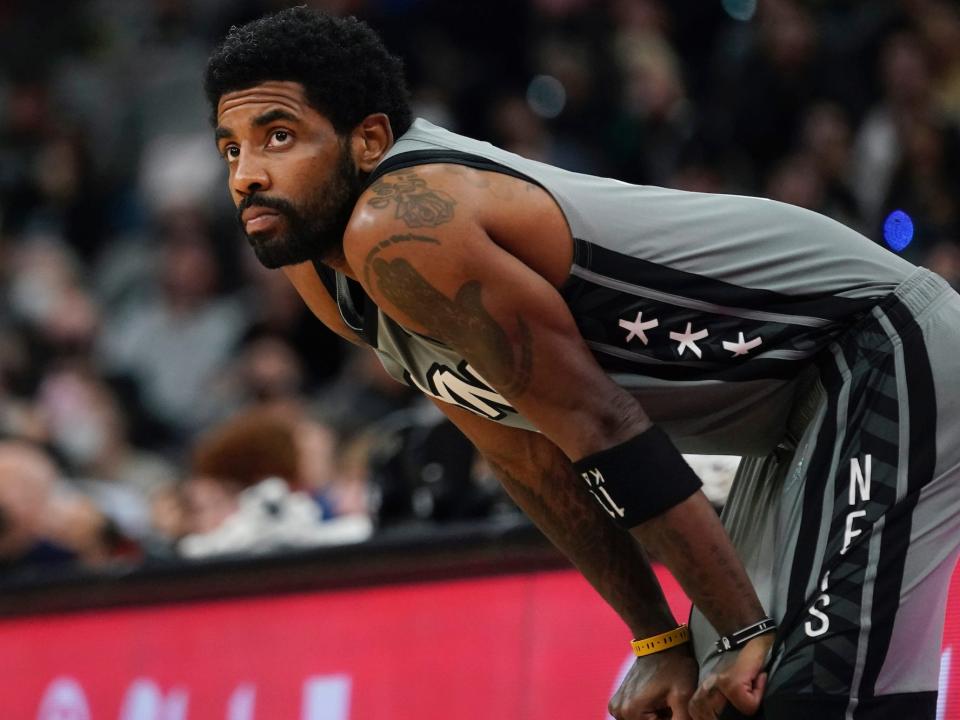 Kyrie Irving stands with his hands on his knees during a game in 2022.