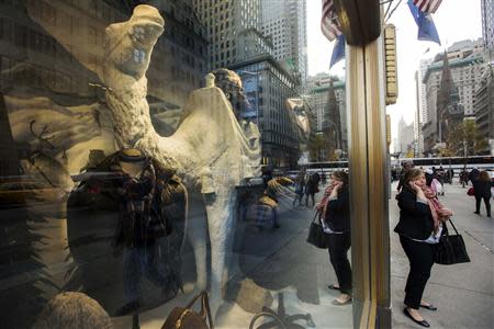 A woman talks on her cell phone in front of holiday window displays at the Bergdorf Goodman store in New York, November 22, 2013. REUTERS/Lucas Jackson