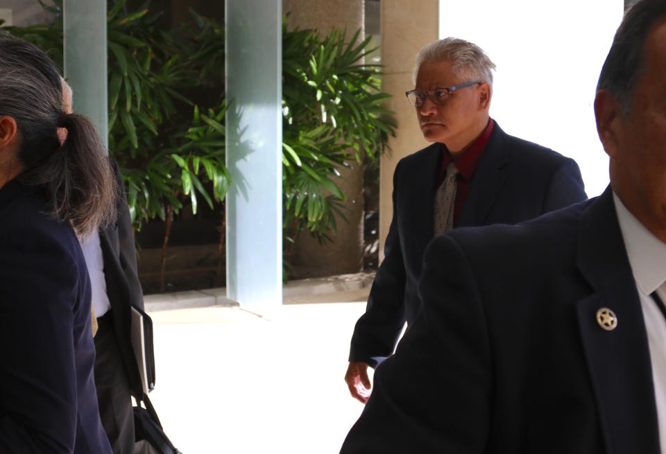 Former Honolulu police chief Louis Kealoha, right, walks into federal court in Honolulu on Wednesday, May 22, 2019. A trial for what has been described as the biggest corruption case in Hawaii history began Wednesday for Kealoha and his former city prosecutor wife, Katherine Kealoha. The two are accused of conspiring to frame Katherine Kealoha's uncle for a crime he did not commit. The Kealoha's were indicted on charges including conspiracy and obstruction. Federal authorities began investigating the two in 2015 and both stepped down from their jobs as the probe deepened. (AP Photo/Caleb Jones)