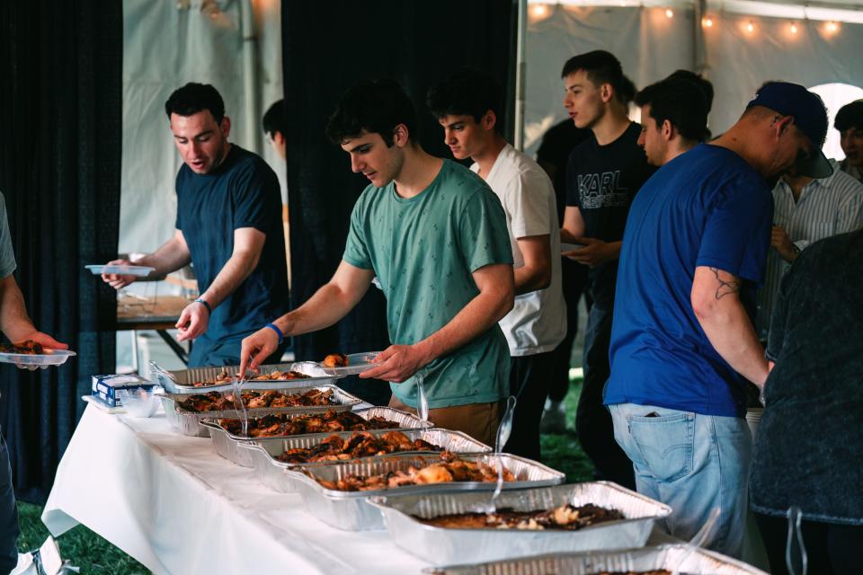 Attendees begin to get food buffet style at Mega Shabbat hosted by Chabad IU on March 29, 2024.