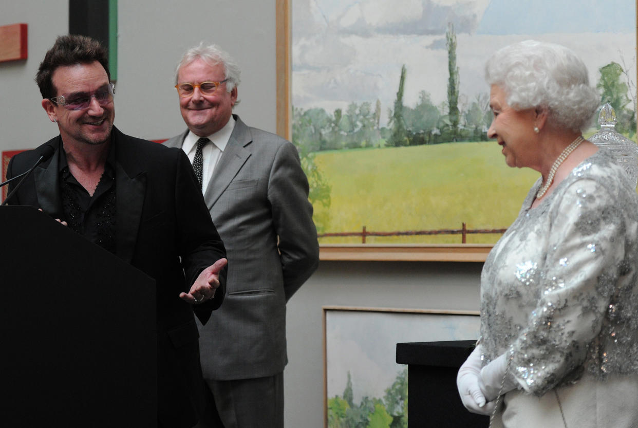 Queen Elizabeth II listens as Bono makes a citation at a special 