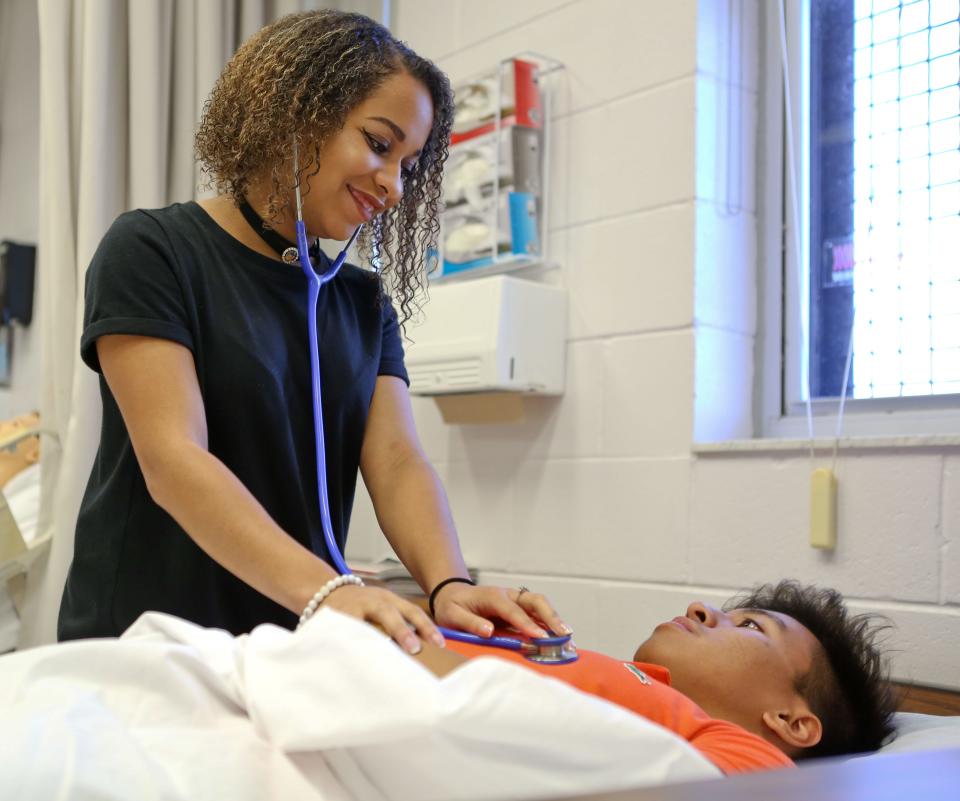 A Gainesville High School student smiles as she listens to another student's heart beat in 2017 in the nursing classroom in Gainesville High School's Academy of Health Profession.