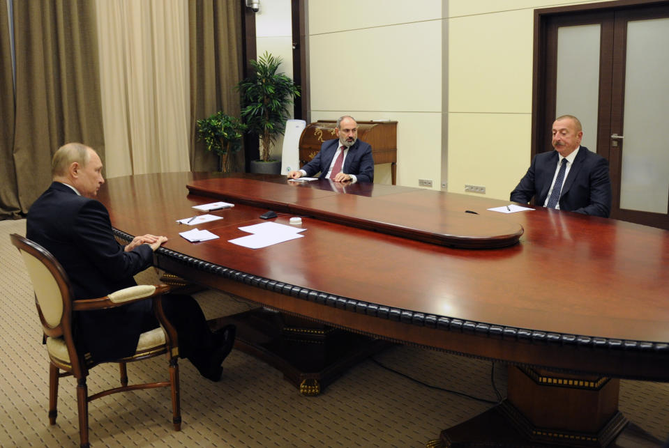 Russian President Vladimir Putin, left, Azerbaijan's President Ilham Aliyev, right, and Armenia's Prime Minister Nikol Pashinyan talk during their meeting in the Bocharov Ruchei residence in the Black Sea resort Sochi, Russia, Friday, Nov. 26, 2021. Russian President Vladimir Putin is hosting the leaders of Armenia and Azerbaijan for talks. The three are expected to discuss ways to resolve the tensions over the separatist region of Nagorno-Karabakh. (Sputnik, Kremlin Pool Photo via AP)