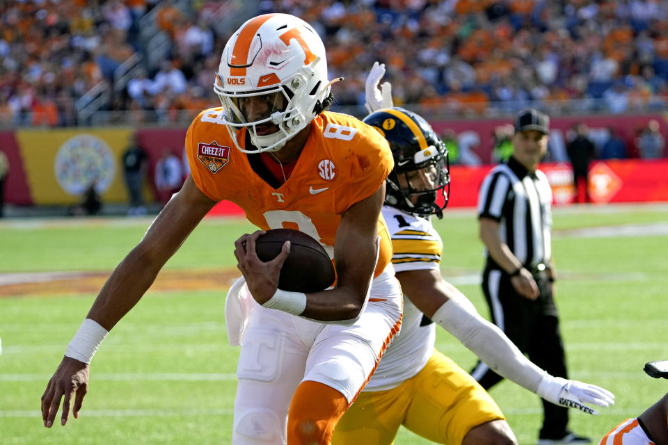 Tennessee quarterback Nico Iamaleava (8) runs past Iowa defensive back Xavier Nwankpa (1) for a touchdown on an 3-yard run during the first half of the Citrus Bowl NCAA college football game, Monday, Jan. 1, 2024, in Orlando, Fla. (AP Photo/John Raoux)