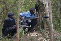 Police officers take cover following a string of explosions from Westgate shopping center in Nairobi, during the third day of a stand off between Kenyan security forces and gunmen inside the building September 23, 2013. Powerful explosions sent thick smoke billowing from the Nairobi mall where militants from Somalia's al Qaeda-linked al Shabaab group threatened to kill hostages on the third day of a raid in which at least 59 have already died. (REUTERS/Siegfried Modola)