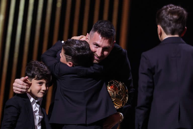 Los pequeños Messi, arriba del escenario: Mateo, Thiago y Ciro, en la ceremonia del Balón de Oro en París (Photo by FRANCK FIFE / AFP)