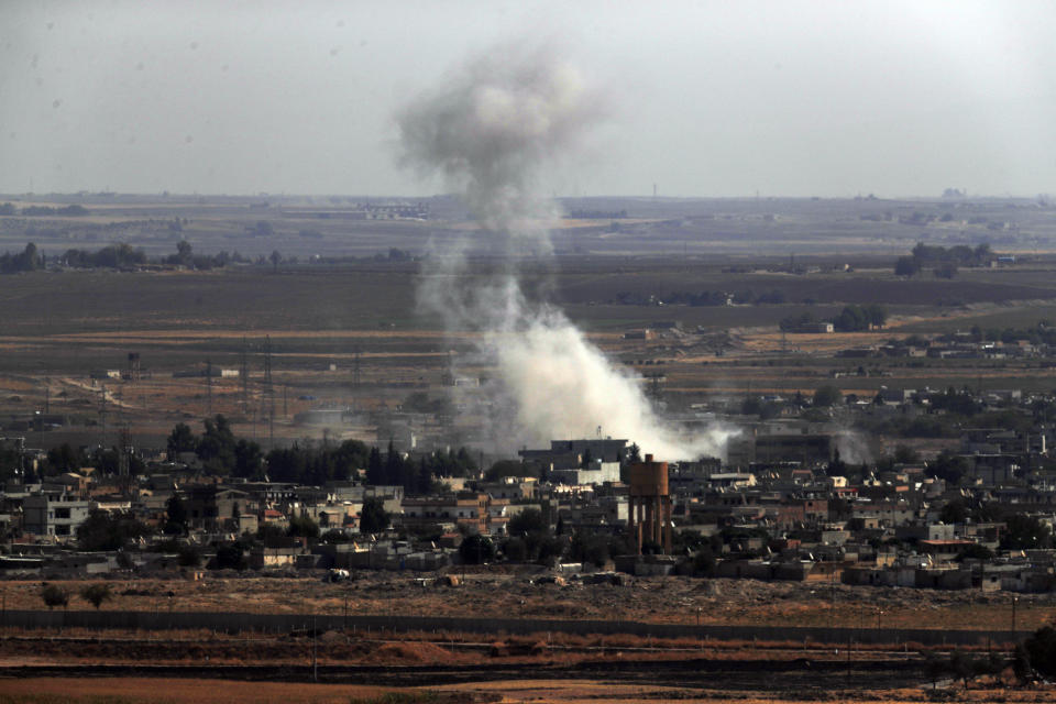 In this photo taken from the Turkish side of the border between Turkey and Syria, in Ceylanpinar, Sanliurfa province, southeastern Turkey, smoke and dust billows from targets in Ras al-Ayn, Syria, caused by bombardment by Turkish forces, Tuesday, Oct. 15, 2019. Turkish artillery on Tuesday pounded suspected Syrian Kurdish positions near the town in northeast Syria amid reports that Kurdish fighters had retaken the town as Turkey pressed ahead with a military incursion that has drawn widespread condemnation. (AP Photo/Lefteris Pitarakis)