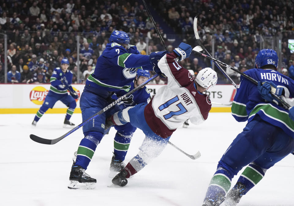 Vancouver Canucks' Luke Schenn (2) checks Colorado Avalanche's Brad Hunt (17) during the second period of an NHL hockey game Thursday, Jan. 5, 2023, in Vancouver, British Columbia. (Darryl Dyck/The Canadian Press via AP)