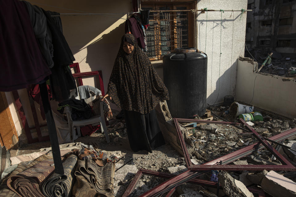 A Palestinian woman inspects her house which was hit by an Israeli airstrike in Gaza City, Monday, Aug. 8, 2022. A cease-fire between Israel and Palestinian militants has taken effect late Sunday in a bid to end nearly three days of violence that has killed dozens of Palestinians. (AP Photo/Fatima Shbair)