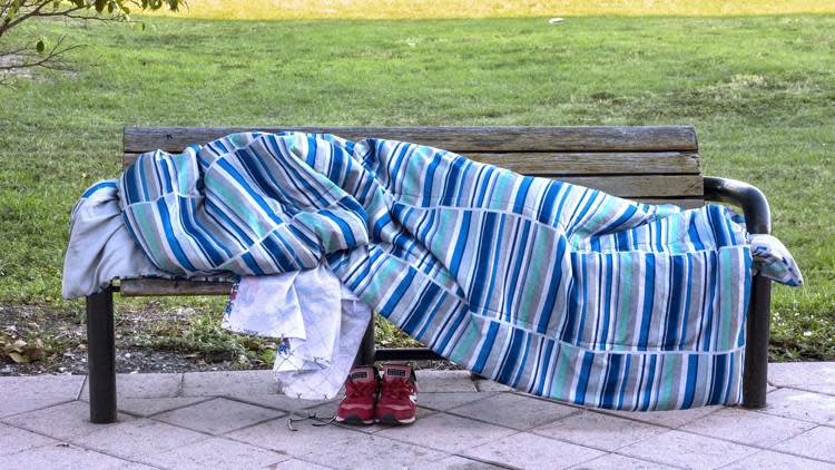 It was 50 degrees as a homeless person slept under a blanket on a bench on Banyan Boulevard at Narcissus Avenue in downtown West Palm Beach.