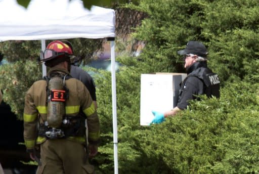 A police officer carries out evidence in a box from the apartment of the James Holmes in Aurora, Colorado. Police believe they have defused the "remaining major threats" in alleged Batman gunman Holmes's booby-trapped apartment, they said Saturday, adding that the devices were designed to kill