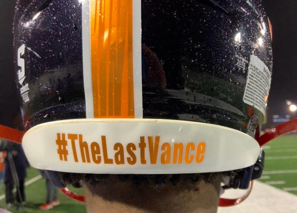 Vance quarterback Austin Grier shows off the back of his helmet and the team slogan #TheLastVance. Vance high school has been renamed in honor of civil rights attorney Julius L. Chambers, but the football team first wants to win one last championship under its original name.