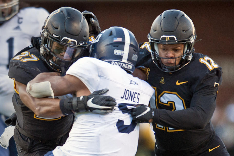 Appalachian State defensive backs Ronald Clarke (27) and Madison Cone (12) take down Georgia Southern running back Amare Jones for a loss in the first half of an NCAA college football game, Saturday, Nov. 27, 2021 at Kidd Brewer Stadium in Boone, N.C. (Walt Unks/The Winston-Salem Journal via AP)