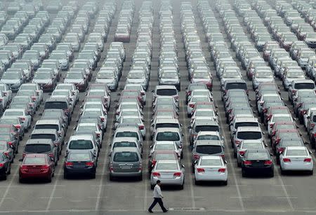 A man walks past a parking lot at Dayaowan port of Dalian, Liaoning province June 10, 2012. REUTERS/Stringer/File Photo