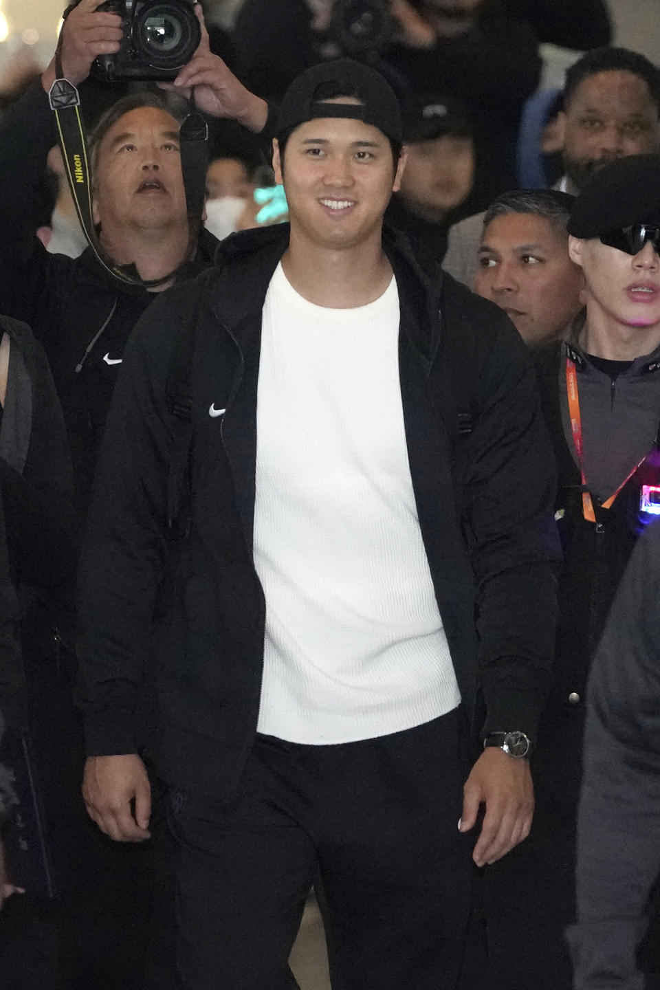 Los Angeles Dodgers' Shohei Ohtani walks with security during the baseball team's arrival at Incheon International Airport, Friday, March 15, 2024, in Incheon, South Korea, ahead of the team's baseball series against the San Diego Padres. (AP Photo/Lee Jin-man)