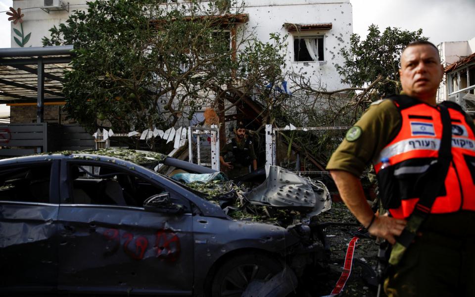 Emergency personnel stand near houses in Haifa damaged in the rocket attack