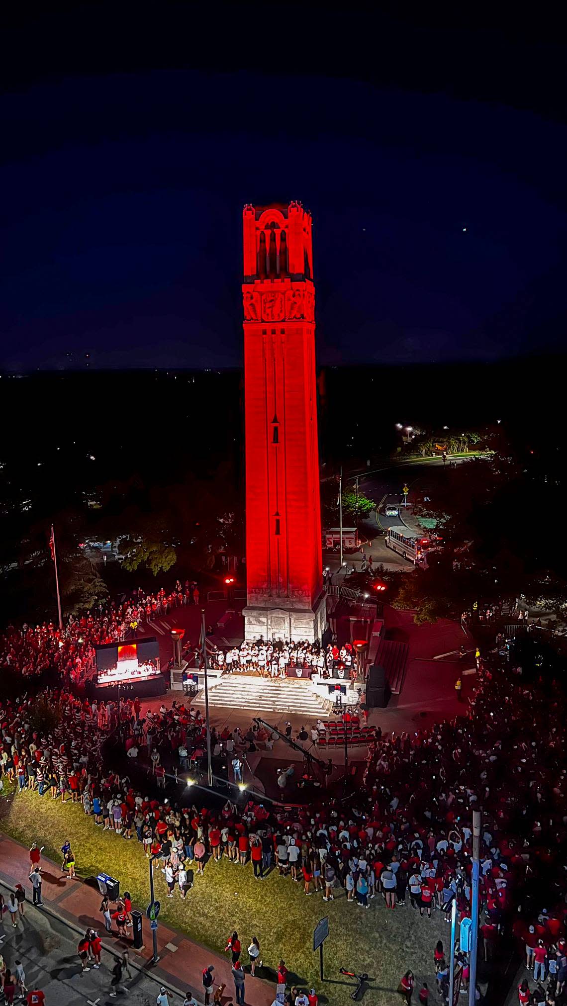 NC State’s Memorial Belltower is bathed in red light as more than a thousand fans celebrate the men’s and women’s basketball teams’ Final Four runs on Monday, April 15, 2024.